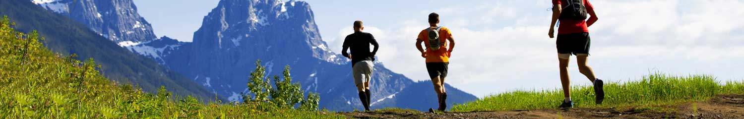 People running on field with mountain in background