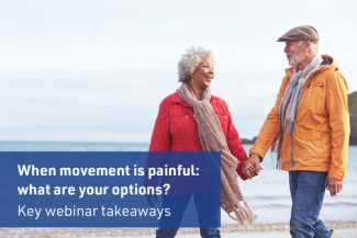 Senior woman holding senior man's hand walking on beach smiling